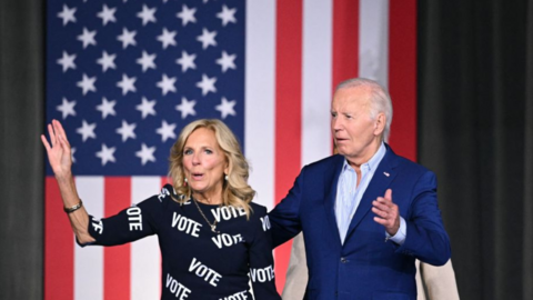 Joe and Jill Biden in front of a flag