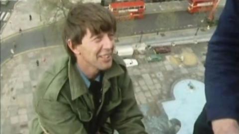 John Noakes, wearing a green jacket, at the top of Nelson's Column