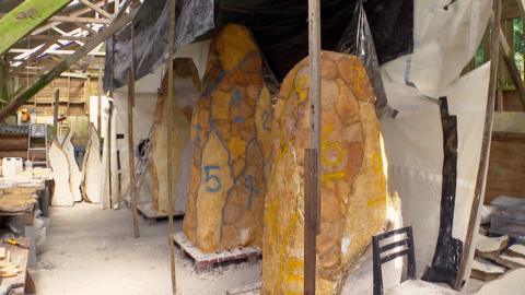 Three tall structures in a shed which will become bronze-covered modern monoliths