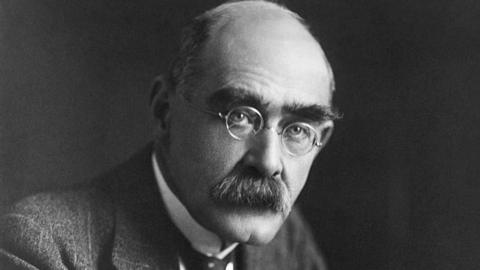 Rudyard Kipling wearing glasses and looking into camera 