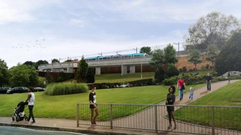 A CGI impression of a blue metro vehicle travelling on a raised track, which sits on a small hill. There are people walking around, and green space below the track.