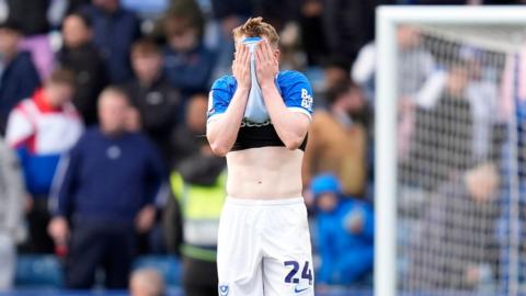 Terry Devlin holds his shirt over his face at full-time