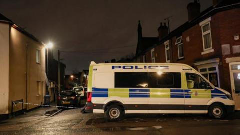 A police vehicle is parked next to a cordon on a street after 200 homes were evacuated following a warrant at an address in Vulcan Street