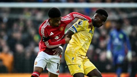 Amad Diallo battles for possession with Crystal Palace captain Marc Guehi