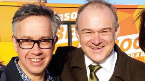 Candidate David Campanale with Sir Ed Davey standing in front of a Lib Dem bus