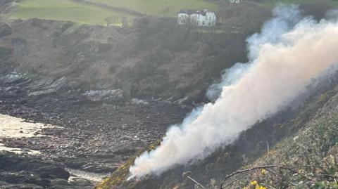 Smoke from the fire on the cliffside