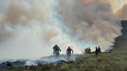A group of firefighters tackling a large-scale wildfire in the Cairngorms.