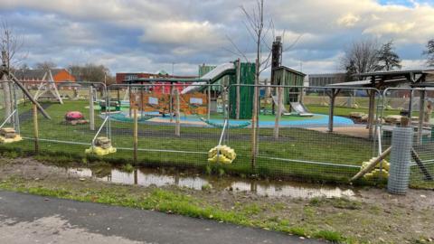 Park surrounded by water and fences