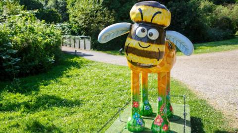 Shaun the Sheep model with yellow body, yellow and green patterned legs, and light blue ears and crossed eyes