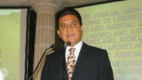 Judge Edmundo Román Pinzón, wearing a black suit and a tie, speaking at an undated event