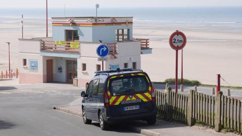 An emergency vehicle which says Gendarmerie on the back, parked up at the beach
