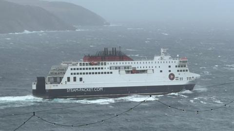 The Manxman ferry in Douglas Bay. It is a large white ship with black and red markings the Steam Packet's logo on the side.