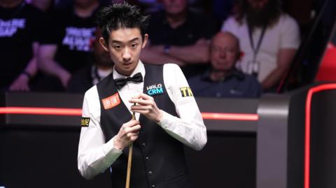 Wu Yize chalks his cue
