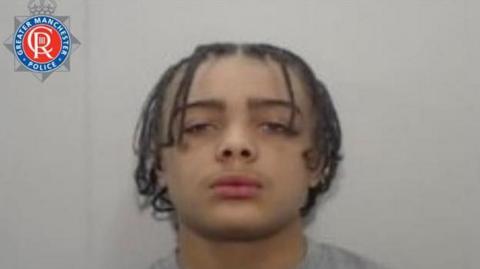 A police mugshot of L'Vaion Peniston, who has his hair tied into braids and is wearning a grey jumper, stares into the camera with a blank expression.