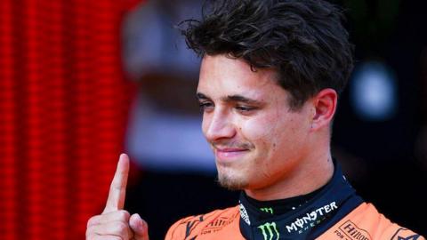 Lando Norris holding one finger in the air after securing pole position at the Austrian Grand Prix