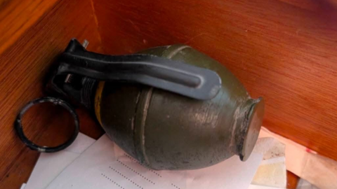 Hand grenade in a drawer on top of some papers