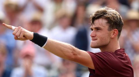 Jack Draper points to the home fans at Queen's