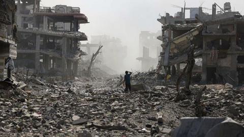 A Palestinian youth stands on a street strewn with rubble following an explosion in the Saftawi neighbourhood, west of Jabalia in the northern Gaza Strip on August 25, 2025