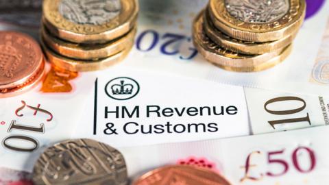 A collection of modern British banknotes surrounding the HM Revenue & Customs heading on a UK Government tax form.