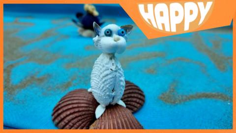 A cat made from sea shells and the Happy logo