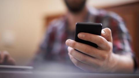 Man's hand holding smartphone