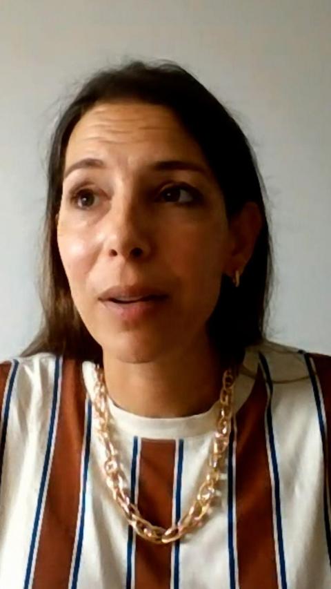 Woman with dark hair and gold necklace