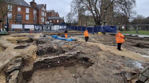 An archaeological excavation in Chesterfield town centre. People are on the site in hi-vis jackets.
