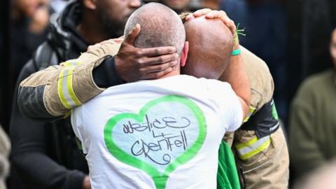 People including firefighters attend the service of remembrance to mark the seventh anniversary of the Grenfell Fire in June 2024