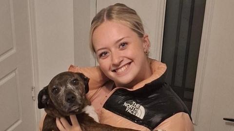 Menyw ifanc yn gafael mewn ci