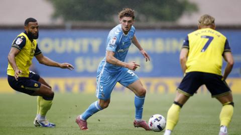 Jack Rudoni (centre) has Oxford players Matt Phillips (left) and Przemyslaw Placheta (right) closing him down