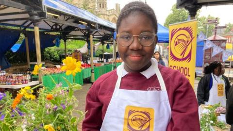 Moyosore from Cauldwell School in Bedford selling flowers on Bedford Market