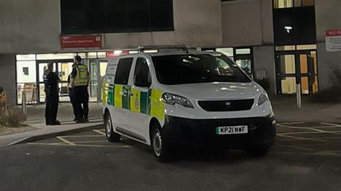 Police officers ourside the A&E department at Aberdeen Royal Infirmary at night.