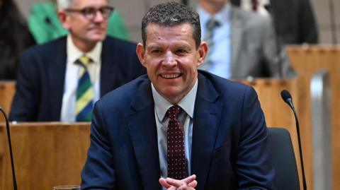 Rhun ap Iorwerth smiling in the Senedd.