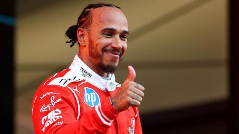 Lewis Hamilton gives a thumbs-up on the Monaco podium 