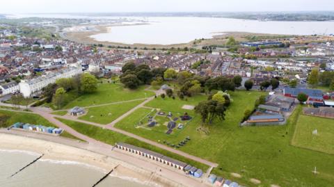 An aerial view of Dovercourt and part of Harwich, both of which are based on a peninsula. Houses and a large park are pictured in the middle and have water either side.