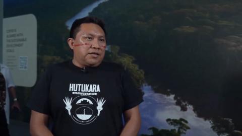 Brazilian indigenous leader stands during interview with BBC at COP30