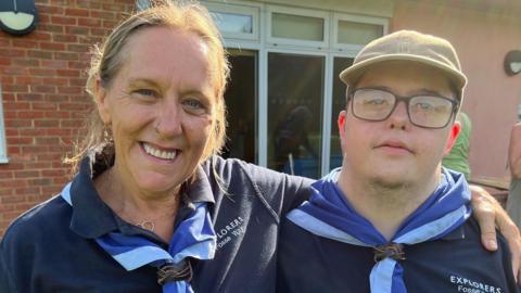 Sharon and her son Roo. Both are wearing a scout uniform and smiling into the camera.