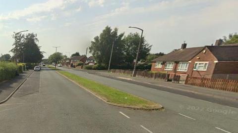 Residental street Ribbleton Hall Drive in Preston on a cloudy day.