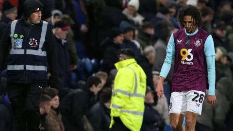 Hannibal Mejbri walks off the pitch, past stewards and fans after being sent off in Burnley's draw with Stoke City