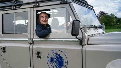 Sir Tony Robinson in a vehicle 