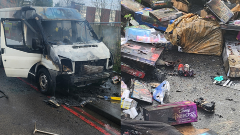 A large burnt out white van, alongside dozens of fire-damaged children's toys and presents.