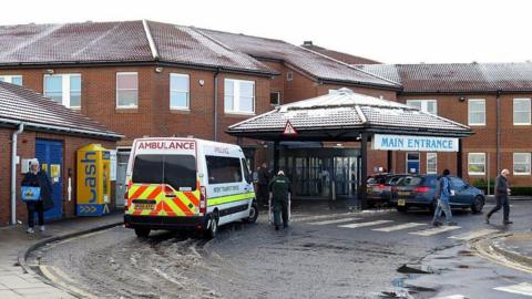 A Google Street View screenshot of the entrance to North Tyneside General Hospital, which is one of the hospitals managed by the trust. An ambulance is outside. There is a dusting of snow on the roof.