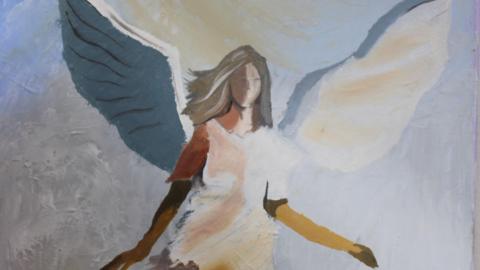 A picture of a painted angel. It has wings and grey hair. The image is on display at the exhibition. 