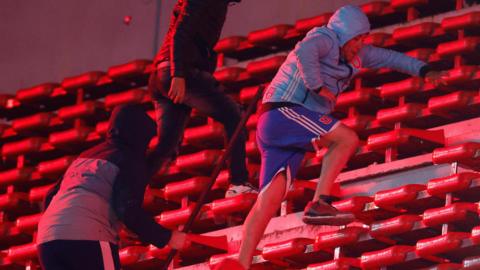 A Universidad de Chile fan being chased by a rival fan at their game away to Independiente in August 2025
