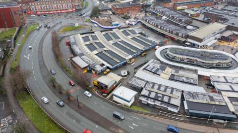 Drone view of the top of Bury Market, showing covered areas next to a road curving around it. 