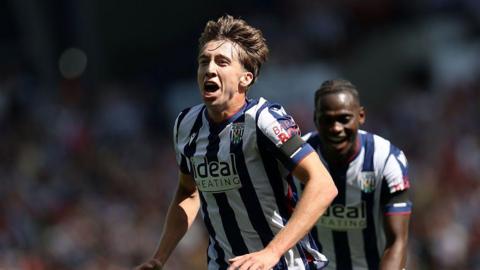 Harry Whitwell runs with his mouth open in celebration after scoring