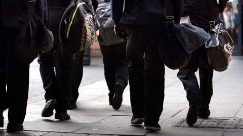 Children walking to school carrying bags