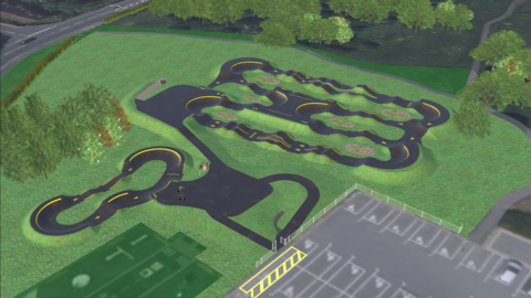 A CGI image showing what the pump track could look like. It is an aerial view of a black track on a green field, near a car park.