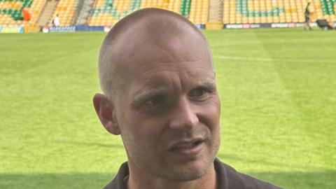 Norwich City boss Liam Manning talking to the media