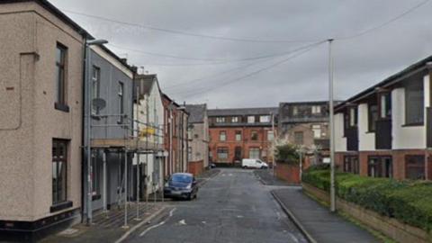 Sussex Street, Rochdale with older and new build terraced homes with scaffolding around one house